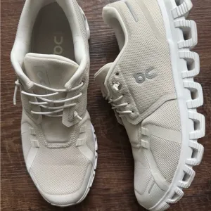 On Running Cream Athletic Shoes with Streamlined Design